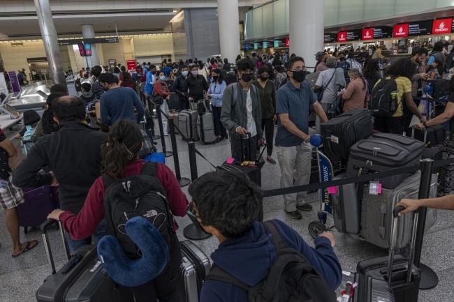 © Bloomberg. Travelers wait to check-in in the international terminal at San Francisco International Airport (SFO) in San Francisco, California, US, on Monday, June 13, 2022. The Biden administration is lifting its requirement that all travelers test negative for coronavirus before flying to the US, amid pressure from airlines that viewed the measure as excessive and blamed it for depressing ticket purchases.