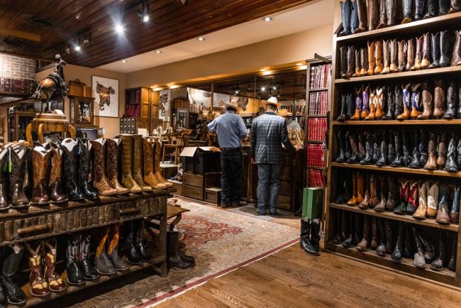 © Bloomberg. Customers shop for boots in Fort Worth, Texas. Photographer: Kathy Tran/Bloomberg