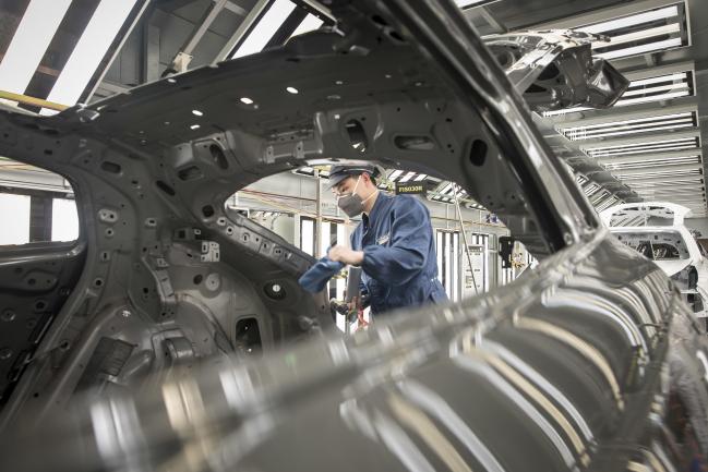 © Bloomberg. An employee wearing a protective mask works on a Lynk & Co. 05 crossover sport utility vehicle (SUV) in the paint shop at the Geely Automobile Holdings Ltd. plant in Ningbo, Zhejiang Province, China, on Tuesday, April 28, 2020. China's manufacturing purchasing managers' index (PMI) jumped to 52 in March, from an historic low of 35.7 in February as activity rebounded from disruptions caused by the coronavirus and containment measures. Photographer: Qilai Shen/Bloomberg