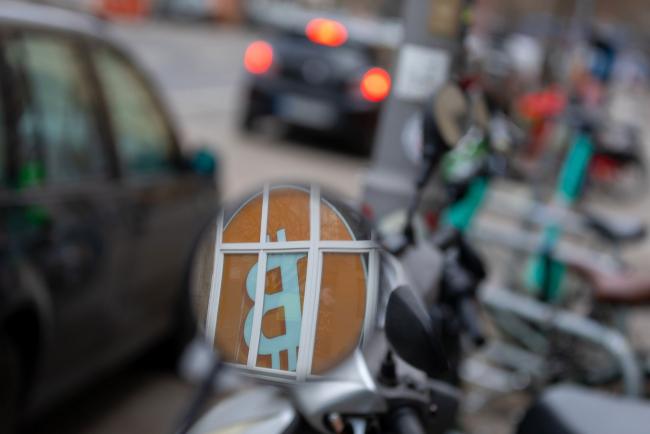 © Bloomberg. The logo of the Bitcoin cryptocurrency is reflected in a motorcycle wing mirror in the Mitte district of Berlin, Germany, on Tuesday, Feb. 15, 2022. Waning turbulence and trading volume could spell trouble for crypto markets, where volatility is part of the appeal. Photographer: Krisztian Bocsi/Bloomberg