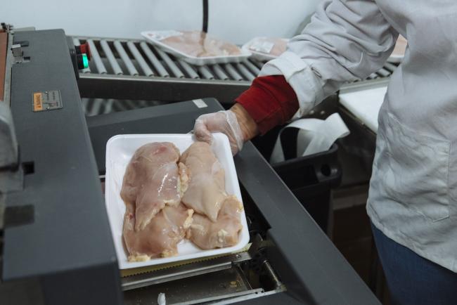 © Bloomberg. A worker places chicken breasts in a machine to be weighed and packaged in the butcher section of a Stew Leonard's supermarket in Paramus, New Jersey, U.S., on Tuesday, May 12, 2020. Stew Leonard Jr. said that meat packing plant the company uses is operating at about 70 percent capacity, and he expects it to rebound to full capacity in about a month, CT Post reported. Photographer: Angus Mordant/Bloomberg