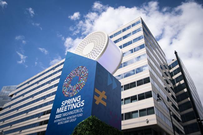 © Bloomberg. International Monetary Fund (IMF) and World Bank spring meetings signage outside the IMF headquarters in Washington, D.C., U.S., on Tuesday, April 19, 2022. The IMF slashed its world growth forecast by the most since the early months of the Covid-19 pandemic, and projected even faster inflation, after Russia invaded Ukraine and China renewed virus lockdowns.