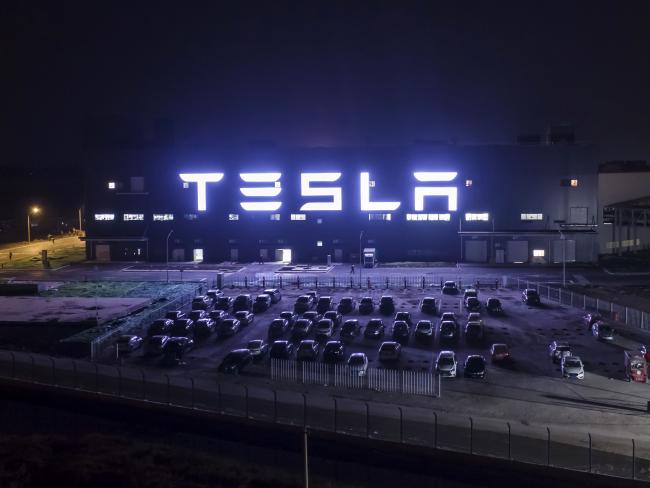 © Bloomberg. The Tesla Inc. Gigafactory stands illuminated at night in Shanghai.