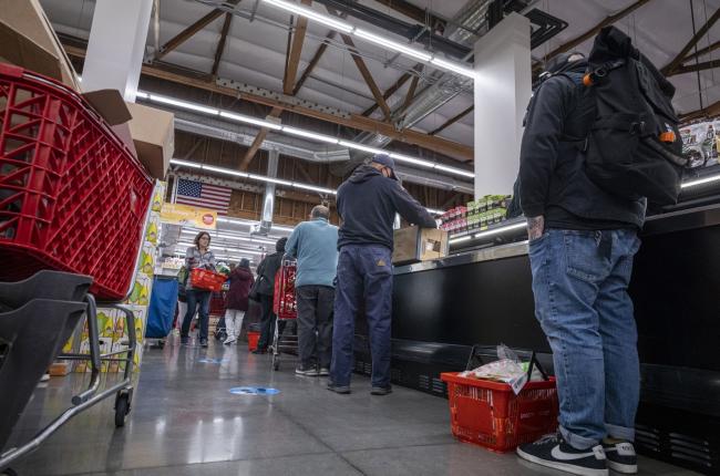 © Bloomberg. Shoppers wait in line to checkout inside a grocery store in San Francisco, California, U.S., on Monday, May 2, 2022. U.S. inflation-adjusted consumer spending rose in March despite intense price pressures, indicating households still have solid appetites and wherewithal for shopping.