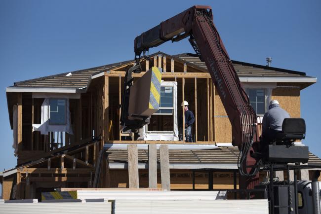 &copy Bloomberg. Contractors work on a new home under construction in Tucson, Arizona, U.S., on Tuesday, Feb. 22, 2022. Sales of new U.S. homes retreated in January after a flurry of purchases at the end of 2021, indicating a jump in mortgage rates may be starting to restrain demand.