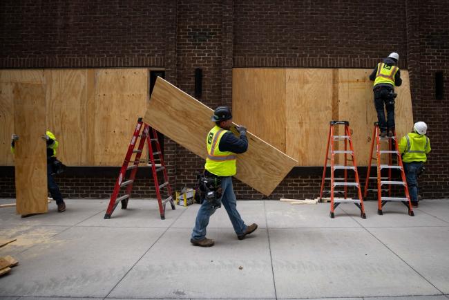 © Bloomberg. Construction workers board up business near the Hennepin County Government Center in Minneapolis, Minnesota, U.S.