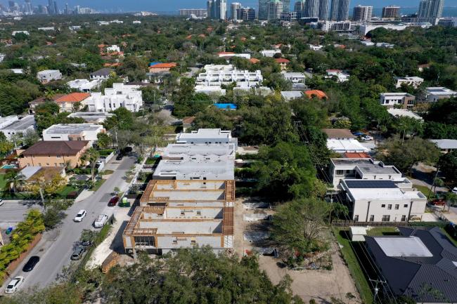 © Bloomberg. MIAMI, FLORIDA - FEBRUARY 18: In an aerial view, homes that, once constructed according to area sales, would fetch over a million dollars each are under construction in the Coconut Grove neighborhood on February 18, 2022 in Miami, Florida. According to a report released by the RealtyHop real estate website, Miami is now the least affordable housing market in the nation passing New York City. The report showed that residents have to spend 78.71% of their income for homeownership in Miami, slightly overtaking New York City's 77.98%. (Photo by Joe Raedle/Getty Images)