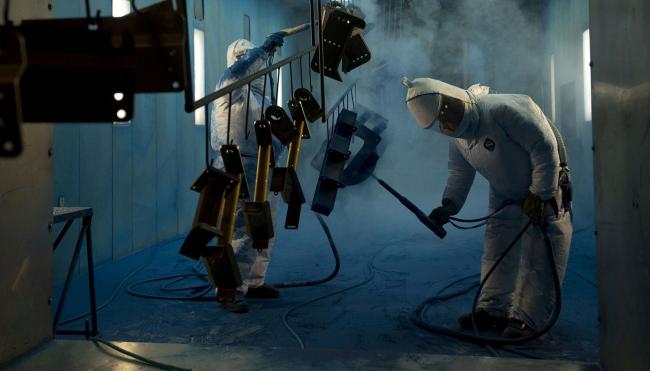 © Bloomberg. Workers powder-coat components at a facility in Williamsburg, Iowa. Photographer: Daniel Acker/Bloomberg