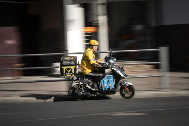 © Bloomberg. A food delivery courier for Meituan travels along a road in Shanghai, China, on Sunday, Nov. 29, 2020. Meituan is scheduled to release third-quarter earnings results on Nov. 30. Photographer: Qilai Shen/Bloomberg