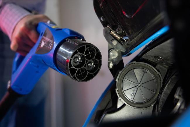 &copy Bloomberg. A worker connects a charging plug to a Nissan Motor Co. Leaf electric vehicle (EV) at the Parus Electro LLC production site in Moscow, Russia, on Friday, Feb. 18, 2022. Russia, one of the world’s biggest oil and gas producers, has a plan to bring more electric vehicles to its roads over the next three years and to build a market for battery-powered cars. Photographer: Andrey Rudakov/Bloomberg