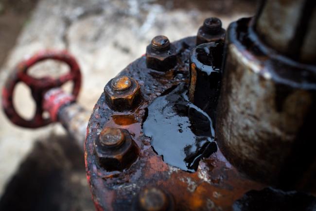 © Bloomberg. Thick black oil sits on the pipe work fitting of an oil pumping jack, also known as 