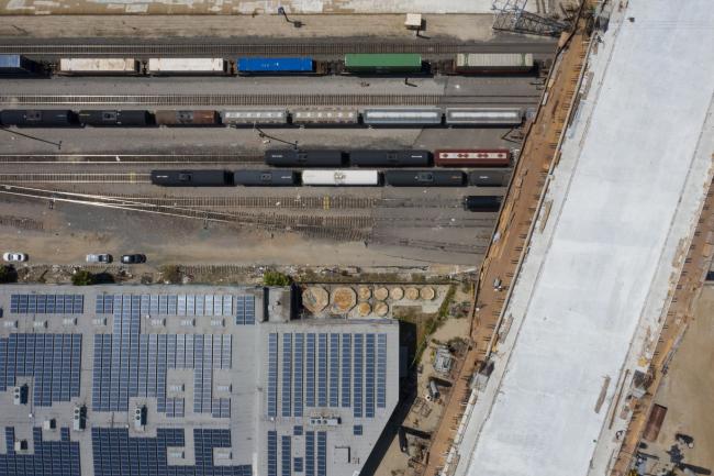 &copy Bloomberg. A rail yard and solar panels adjacent to the Sixth Street Viaduct replacement project in Los Angeles, California, U.S. on Tuesday, April 6, 2021. The Ribbon of Light is the name of the ten arches that will make up the new Sixth Street Viaduct connecting downtown L.A.'s Arts District with Boyle Heights.