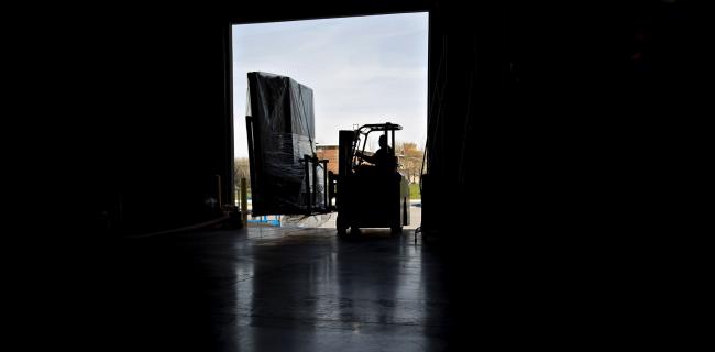 © Bloomberg. A worker uses a forklift to move packages at a robotics facility in Baltimore. Photographer: Andrew Harrer/Bloomberg