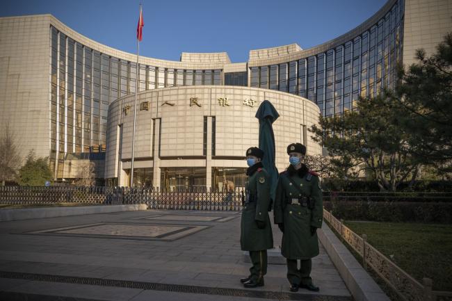 © Bloomberg. People's Liberation Army soldiers stand in front of the People's Bank of China (PBOC) in Beijing, China, on Monday, Dec. 13, 2021. Economists predict China will start adding fiscal stimulus in early 2022 after the country’s top officials said their key goals for the coming year include counteracting growth pressures and stabilizing the economy. Photographer: Andrea Verdelli/Bloomberg