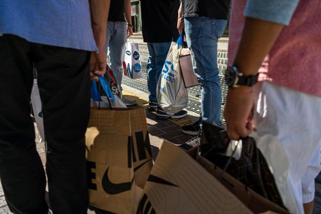 © Bloomberg. Shoppers carry bags in San Francisco.