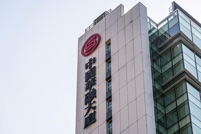 © Bloomberg. Signage atop the China Huarong Tower, which houses the headquarters of China Huarong International Holdings Ltd., a unit of China Huarong Asset Management Co., center, in Hong Kong, China, on Tuesday, April 13, 2021. Growing panic over the financial health of one of China’s largest bad-debt managers China Huarong Asset Management Co. spilled into the broader market, as traders circulated a Caixin report that openly considered the worst-case scenario for the company. Photographer: Lam Yik/Bloomberg