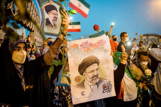 © Bloomberg. Supporters hold photographs of Ebrahim Raisi, Iran's president, as they celebrate his presidential election win in Imam Hossein Square in Tehran, Iran, on Saturday, June 19, 2021. Voters overwhelmingly picked Raisi on Friday, albeit on a low turnout.