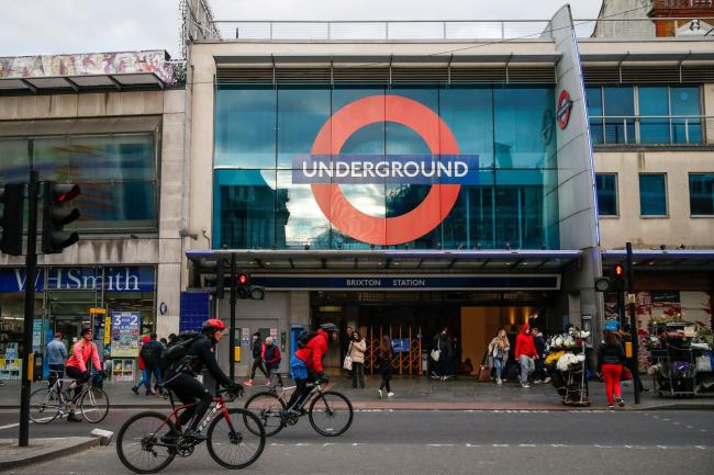 © Bloomberg. Cyclists ride pass Brixton London Underground Station in London, U.K., on Wednesday, April 7, 2021. British voters' attitudes are hardening against the European Union in the wake of the clashes between London and Brussels over coronavirus vaccines that have marked the 100 days since the U.K. completed its divorce from the bloc. Photographer: Hollie Adams/Bloomberg