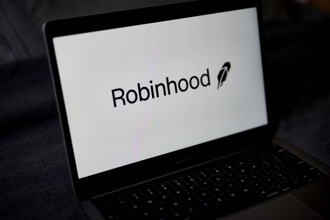 © Bloomberg. The Robinhood logo on a laptop computer arranged in the Brooklyn borough of New York, U.S., on Saturday, Dec. 19, 2020. Robinhood Markets will pay $65 million to settle allegations that it failed to properly inform clients it sold their stock orders to high-frequency traders and other firms, putting a major compliance headache behind the brokerage even as new ones emerge. Photographer: Gabby Jones/Bloomberg