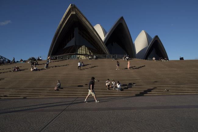 &copy Bloomberg. Visitors gather outside the Sydney Opera House during New Year's Eve celebrations in Sydney, Australia, on Friday, Dec. 31, 2021. Australia's most populous state reported a 73% surge in new Covid-19 cases on Friday, an unwelcome spike that is casting a cloud on New Year festivities as authorities urge residents to still party on. Photographer: Brent Lewin/Bloomberg