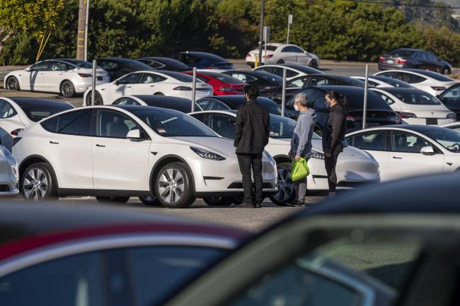 © Bloomberg. Customers at a Tesla dealership in Colma, California. Photographer: David Paul Morris/Bloomberg