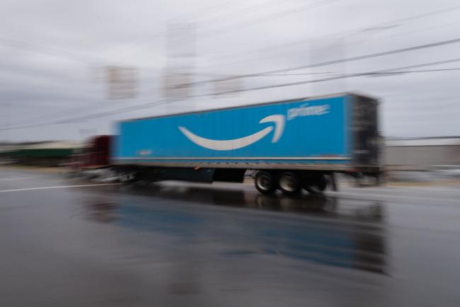 © Bloomberg. A semi truck with the Amazon.com Inc. Prime logo travels along a road outside the company's BHM1 Fulfillment Center in Bessemer, Alabama, U.S., on Saturday, Feb. 6, 2021. The campaign in Bessemer to unionize Amazon workers has drawn national attention and is widely considered a once-in-a-generation opportunity to breach the defenses of the world’s largest online retailer, which has managed to keep unions out of its U.S. operations for a quarter-century. Photographer: Elijah Nouvelage/Bloomberg