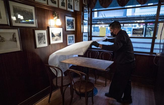 © Bloomberg. A worker puts down a table cloth at a restaurant in San Francisco. Photographer: David Paul Morris/Bloomberg