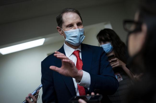 © Bloomberg. Senator Ron Wyden, a Democrat from Oregon, speaks to members of the media while arriving for a vote in the basement of the U.S. Capitol in Washington, D.C., U.S., on Tuesday, Aug. 3, 2021. The Senate majority leader's plan to pass a $550 billion infrastructure bill this week hit a potential obstacle from a surprising source when a key Republican announced he tested positive for Covid-19 and would quarantine for 10 days. Photographer: Al Drago/Bloomberg