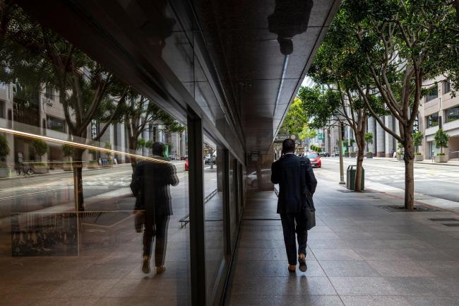 © Bloomberg. A pedestrian on California Street in the financial district of San Francisco, California, U.S., on Monday, May 9, 2022. From Wall Street to Silicon Valley, companies fearful of losing talent are tweaking or scrapping dictates around how often workers need to be at their desks. Photographer: David Paul Morris/Bloomberg