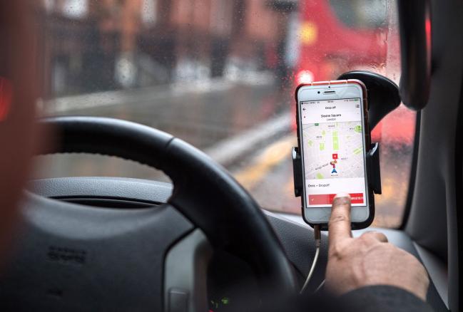 © Bloomberg. A driver uses the Uber Technologies Inc. ride-hailing service smartphone app to complete passenger drop-off in this arranged photograph in London, U.K., on Friday, Dec. 22, 2017. Uber will be regulated in European Union countries as a transport company after the bloc's top court rejected its claim to be a digital service provider, a decision that could increase legal risks for other gig-economy companies including Airbnb.