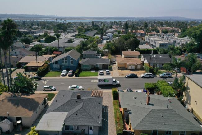 © Bloomberg. A FedEx Corp. truck drives past homes in this aerial photograph taken over the Pacific Beach neighborhood of San Diego, California, U.S., on Wednesday, Sept. 2, 2020. U.S. sales of previously owned homes surged by the most on record in July as lower mortgage rates continued to power a residential real estate market that's proving a key source of strength for the economic recovery. Photographer: Bing Guan/Bloomberg