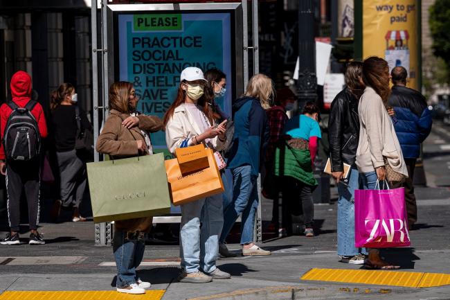 © Bloomberg. Pedestrians carry shopping bags while waiting to cross Geary Street in San Francisco. Photographer: David Paul Morris/Bloomberg