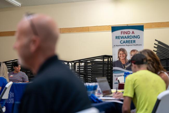 © Bloomberg. Appalachian Regional Healthcare signage seeking job applications during a job fair at a community center in Beattyville, Kentucky, U.S., on Wednesday, July 28, 2021. Applications for U.S. state unemployment insurance rose unexpectedly by the most since late March, underscoring week-to-week volatility in an otherwise improving labor market.