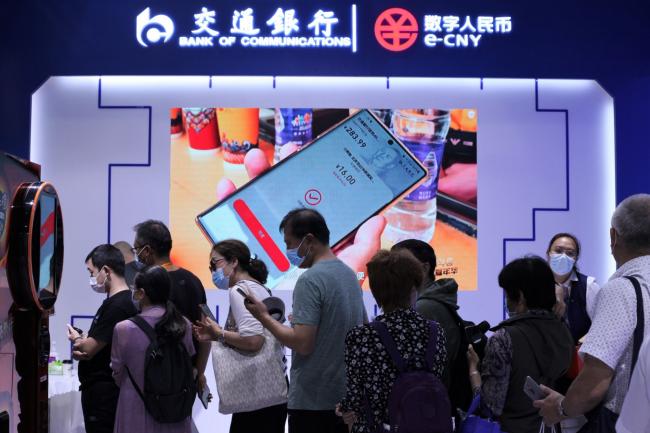 © Bloomberg. Visitors lined up to buy discounted coffees from a machine using digital yuan at the Bank of Communications booth at the trade fair in Beijing.