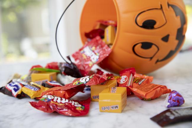 &copy Bloomberg. Mars Inc. and Hershey Co. brand Halloween candy is displayed for a photograph beside a pumpkin themed treat bucket in Tiskilwa, Illinois, U.S., on Sunday, Sept. 20, 2020. Costume-sellers appear to be facing one of their scariest fall seasons in a long time, even as confectioners could see sales hold steady from past years, with some candy brands even expecting an uptick. Photographer: Daniel Acker/Bloomberg