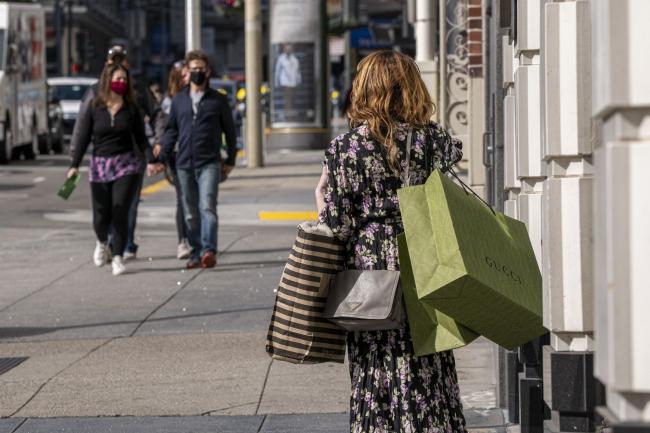 © Bloomberg. A pedestrian carries shopping bags in San Francisco.