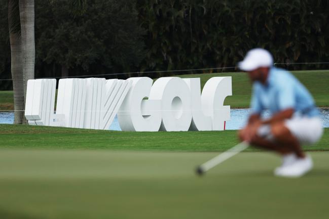 © Bloomberg. Signage is seen as Charl Schwartzel of Stinger GC lines up a putt on the fourth green during the team championship stroke-play round of the LIV Golf Invitational - Miami at Trump National Doral Miami on October 30, 2022 in Doral, Florida. (Photo by Patrick Smith/LIV Golf via Getty Images)