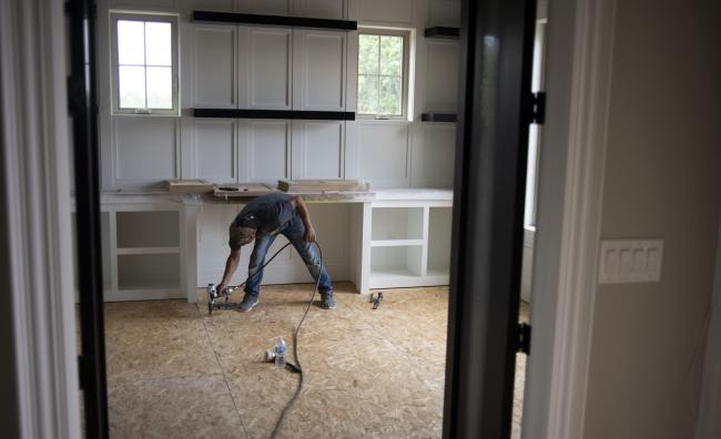 © Bloomberg. A worker uses a nail gun in a home under construction in Dublin, Ohio.