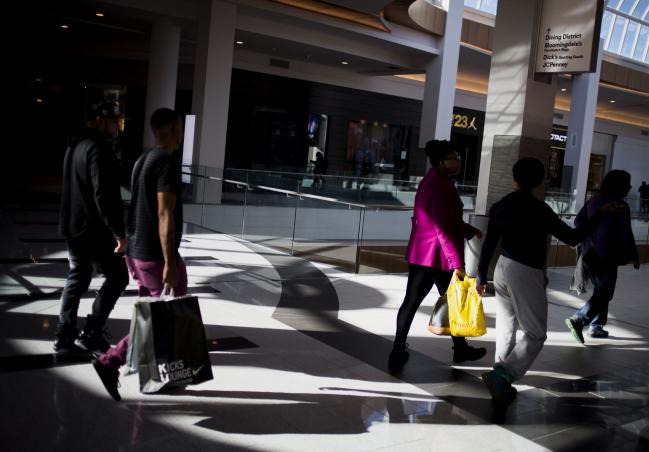 © Bloomberg. Shoppers carry bags while walking at a mall in Garden City, New York. Photographer: John Taggart/Bloomberg