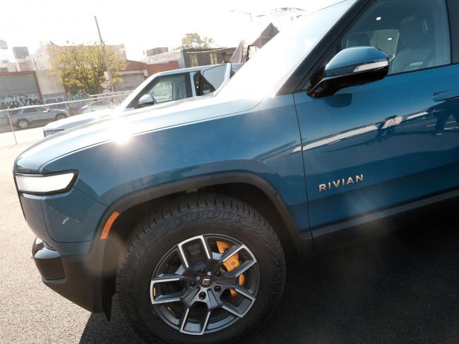 © Bloomberg. NEW YORK, NEW YORK - NOVEMBER 09: The new all-electric pickup truck by Rivian, the R1T, sits at one of its facilities on November 09, 2021 in the Brooklyn borough of New York City. The company, which makes electric trucks and is backed by Amazon and Ford, has has been valued at $64 billion ahead of its IPO tomorrow. (Photo by Spencer Platt/Getty Images)