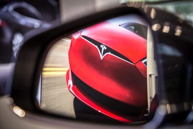 &copy Bloomberg. A badge sits on the hood of a Model S electric vehicle displayed inside a Tesla Inc. store in Barcelona, Spain, on Thursday, July 11, 2019. Tesla is poised to increase production at its California car plant and is back in hiring mode, according to an internal email sent days after the company wrapped up a record quarter of deliveries.