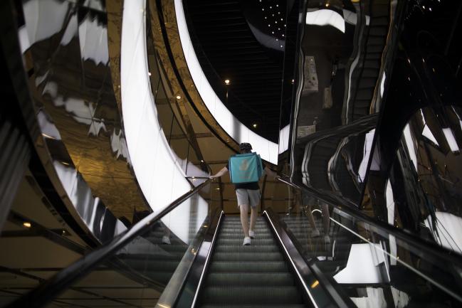 © Bloomberg. A delivery worker rides an escalator in Sydney, Australia, on Monday, Feb. 28, 2022. Australia is scheduled to release gross domestic product (GDP) figures on March 2. Photographer: Brent Lewin/Bloomberg