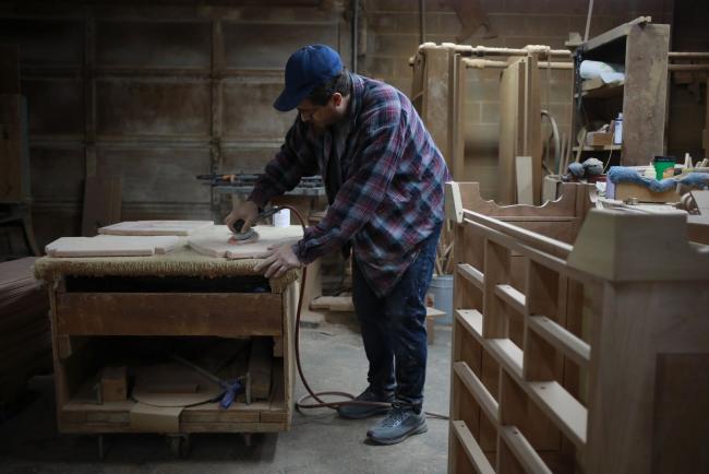© Bloomberg. A factory worker sands down a piece of a wooden chair at a furniture shop in Auburn, Kentucky. Photographer: Luke Sharrett/Bloomberg