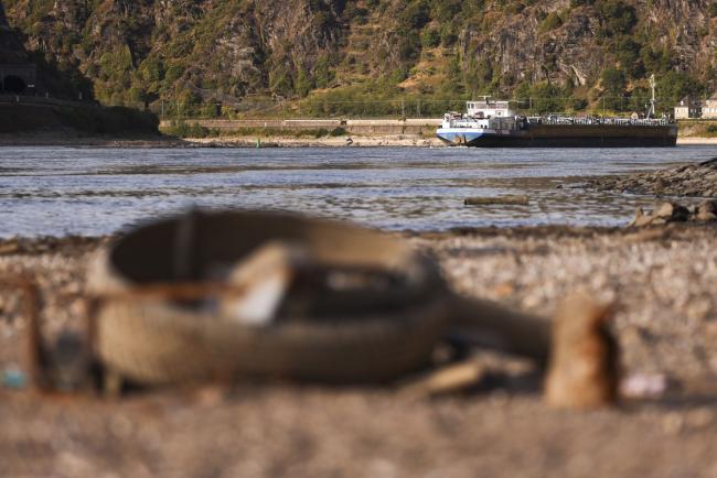 © Bloomberg. A barge passes exposed riverbed on the Rhine near Loreley, Germany. Photographer: Alex Kraus/Bloomberg