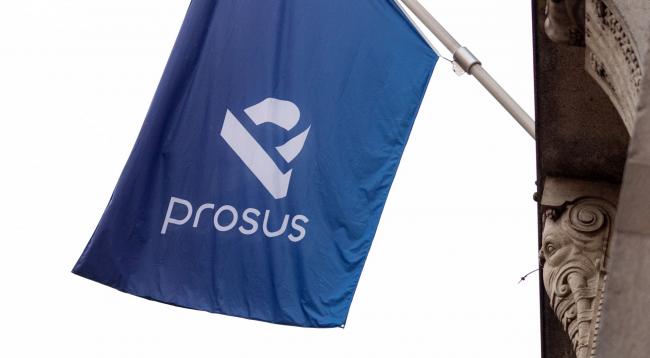 © Bloomberg. A Prosus flag is displayed ahead of the trading debut of the new Prosus NV unit of Naspers Ltd., outside the Amsterdam Stock Exchange, operated by Euronext NV, in Amsterdam, Netherlands, on Wednesday, Sept. 11, 2019. Naspers will retain 73% of the new company, which will house everything from a 31% stake in Chinese online giant Tencent to food delivery and advertising firms from the U.S. to India and Brazil. Photographer: Bloomberg/Bloomberg