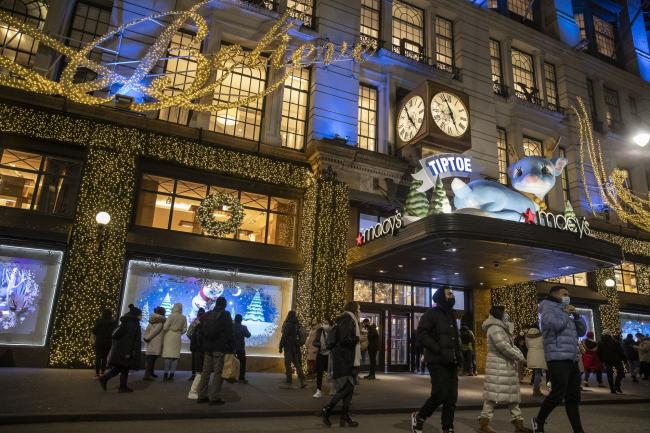 &copy Bloomberg. Shoppers walk past Macy's in New York, U.S., on Monday, Dec. 27, 2021. U.S. holiday sales jumped 8.5% from last year as consumers spent more money on clothes, jewelry and electronics, a report from Mastercard SpendingPulse showed.