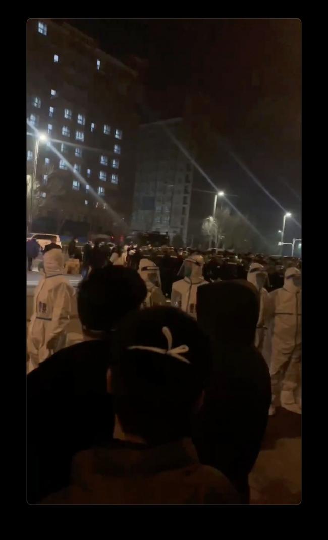 &copy Bloomberg. Screenshot from video of police officers outside the dormitory compound.