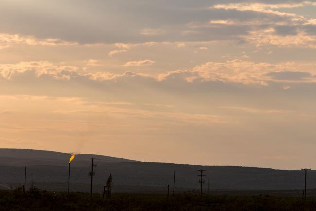 © Bloomberg. Methane gas is flared just off U.S. Route 285 near Carlsbad, New Mexico, U.S., on Tuesday, Aug. 6. 2019. New Mexico's Governor Michelle Lujan Grisham is balancing her concern over the catastrophic effects of climate change with the state's extraordinary dependence on oil and gas. Photographer: Steven St John/Bloomberg