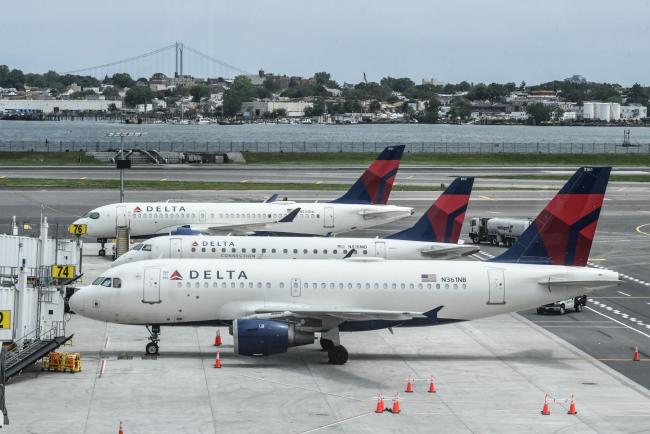 © Bloomberg. Delta Air Lines planes on the tarmac during a tour of Terminal C at LaGuardia Airport (LGA) in the Queens borough of New York, US, on Wednesday, June 1, 2022. Delta Air Lines said it will trim about 100 flights a day in the US and Latin America from July 1 through Aug. 7 to help it recover faster from bad weather, higher-than-expected worker absences and other issues that have rattled recent operations. Photographer: Stephanie Keith/Bloomberg