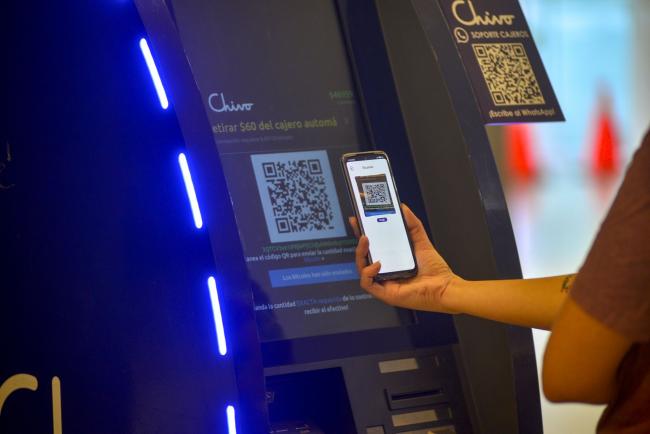 © Bloomberg. A customer uses a Chivo Bitcoin automated teller machine at the Cascadas shopping mall in San Salvador.